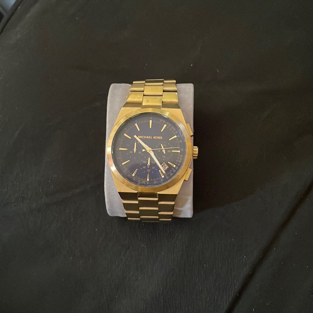 Gold Michael Kors watch with blue face and date